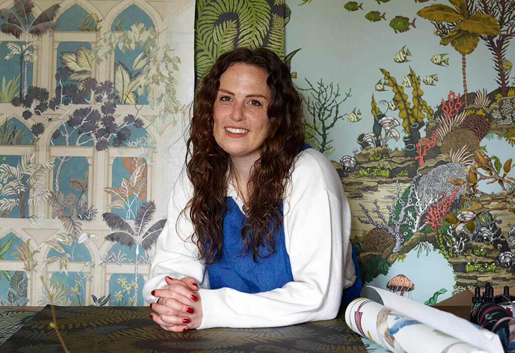 Josephine Munsey in her studio hand painting and drawing wallpaper designs